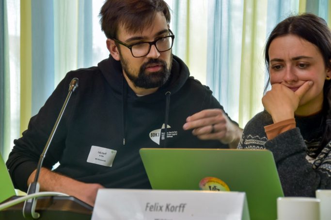 Ein Mann und eine Frau überlegen am Tisch.